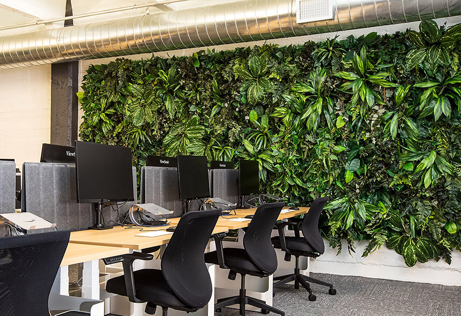 Zielona ściana ze sztucznych roślin w pomieszczeniu biurowym