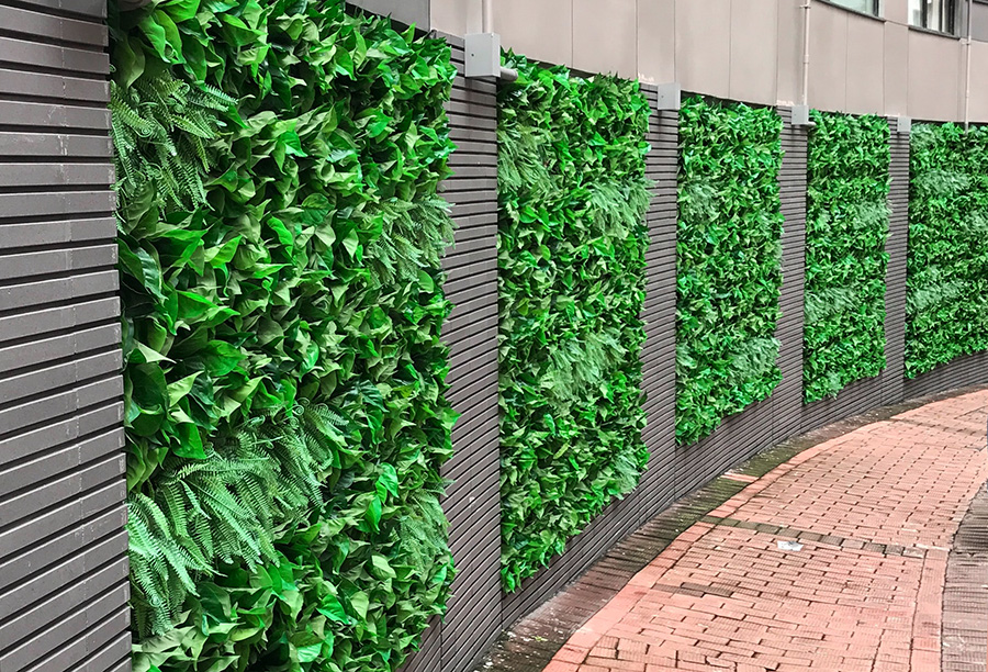Zielona ściana ze sztucznych roślin